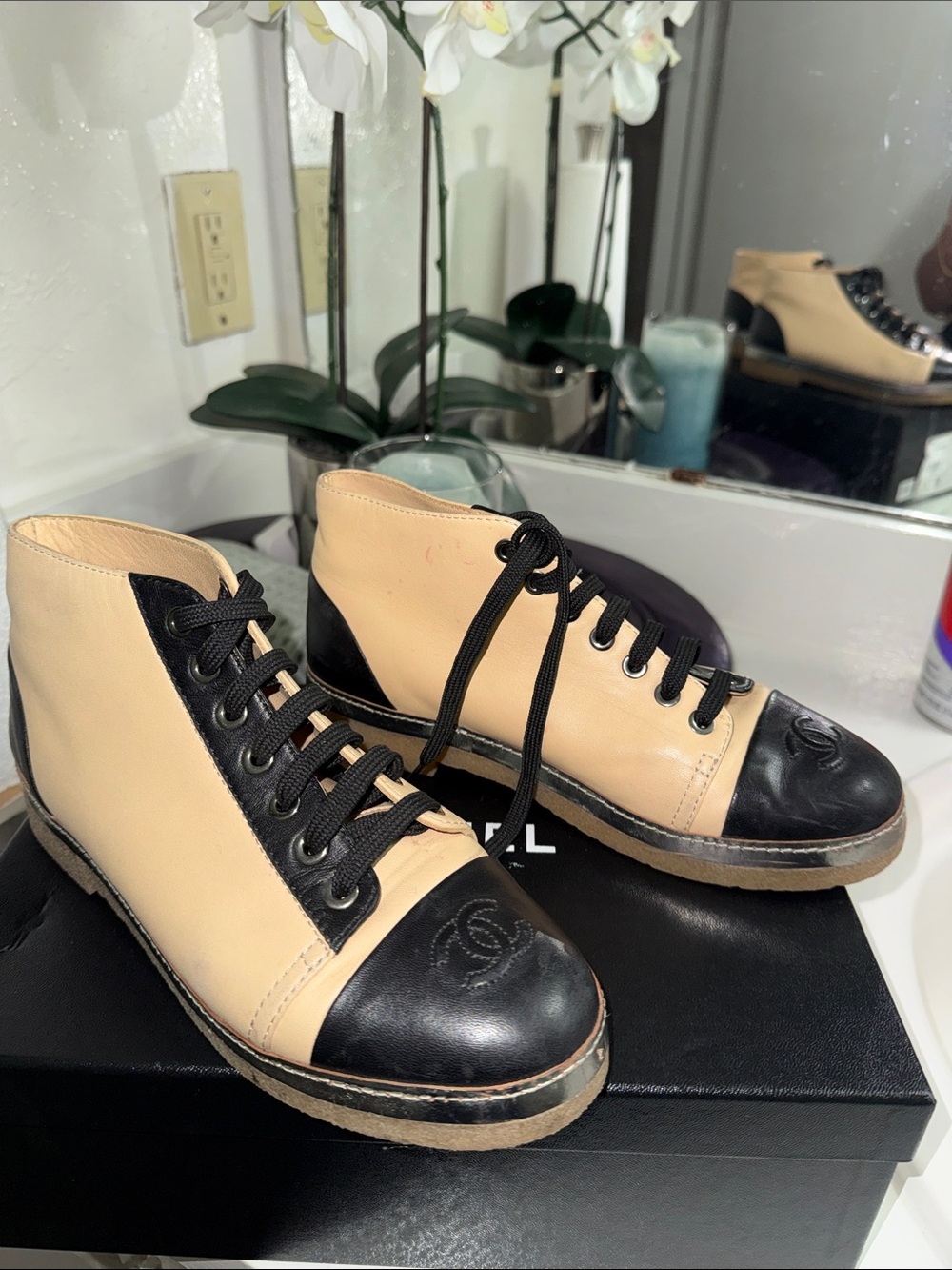 CHANEL Two-Tone Leather High-Top Sneakers in Beige & Black